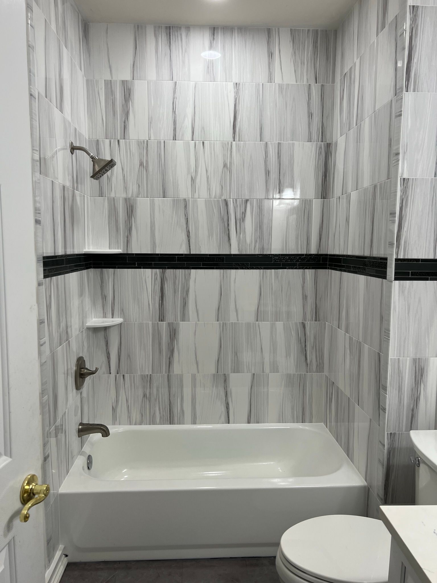 A bathroom with a bathtub , toilet and shower.