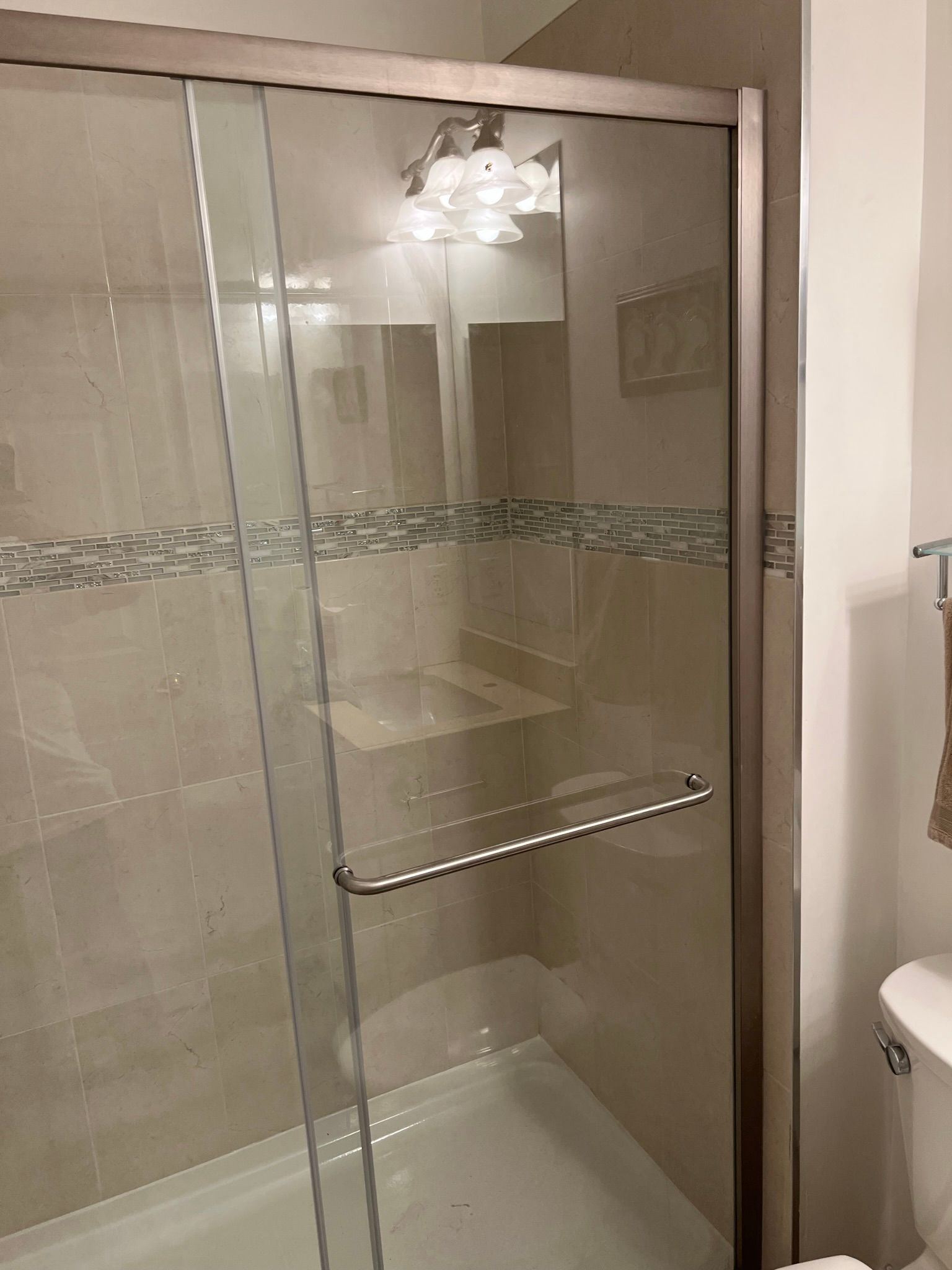 A bathroom with a sliding glass shower door and a bathtub.