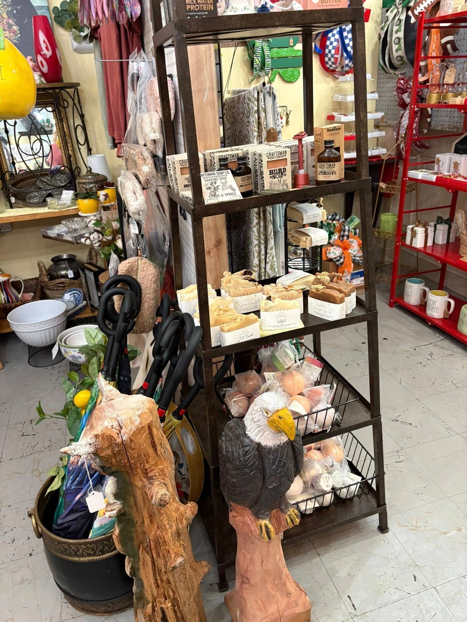 Small storefront display with rustic bird sculptures, shelves of pottery, and decorative items