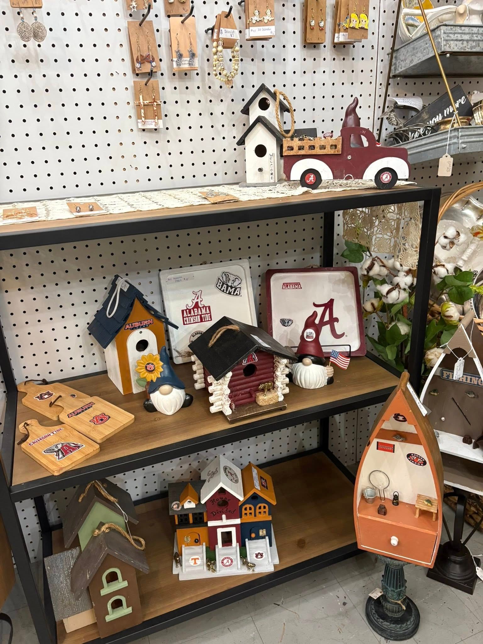 Shelves of small handcrafted wooden birdhouses and painted decor in a shop display