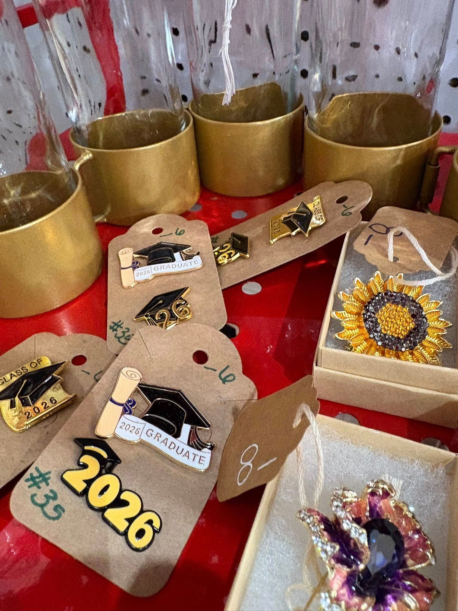 Decorated gold “2026” craft number with glittery accents and crowns on a red table