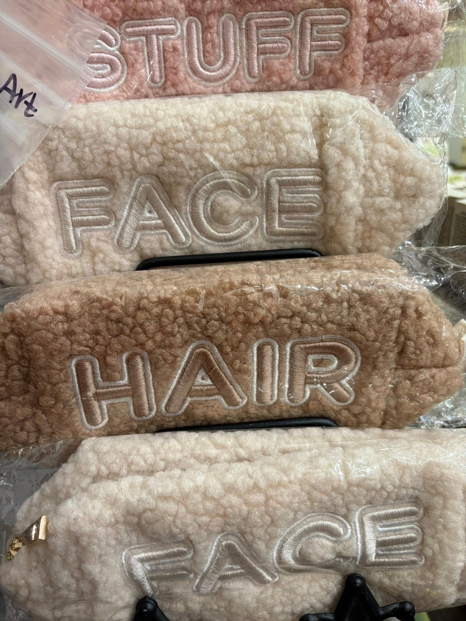 Stacked fuzzy hair clips labeled “STUFF,” “FACE,” and “HAIR” in beige and brown tones