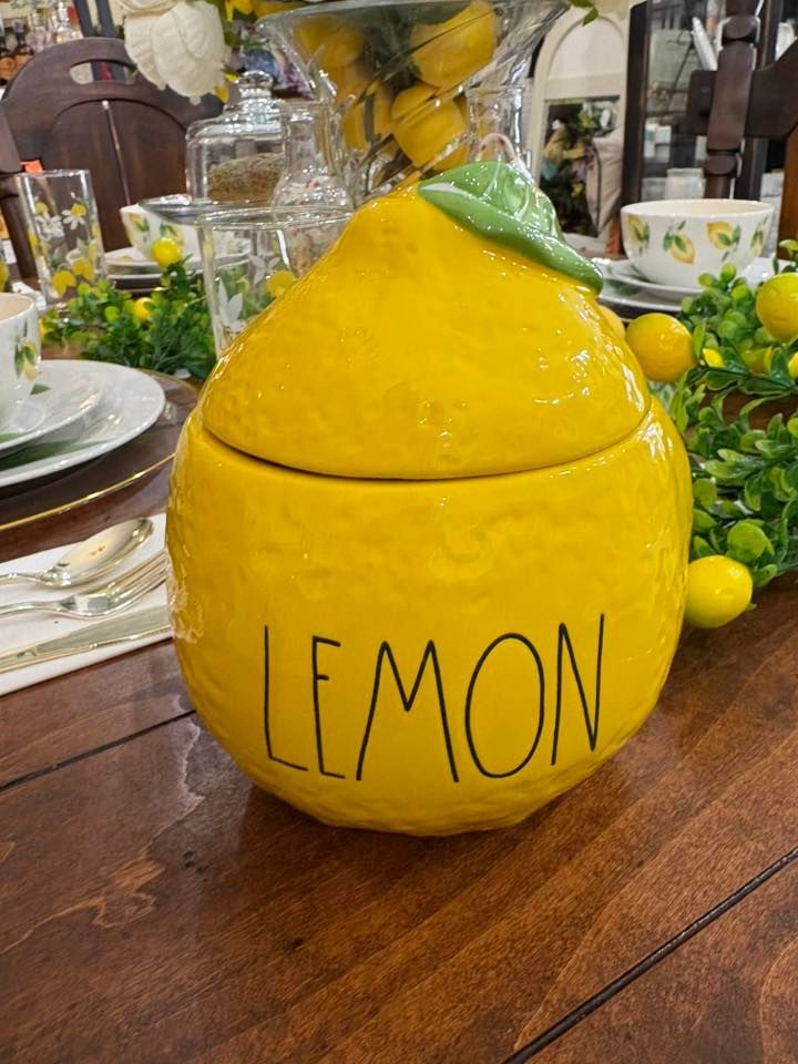 Yellow lemon-shaped table decoration with “LEMON” written on it at a dining table