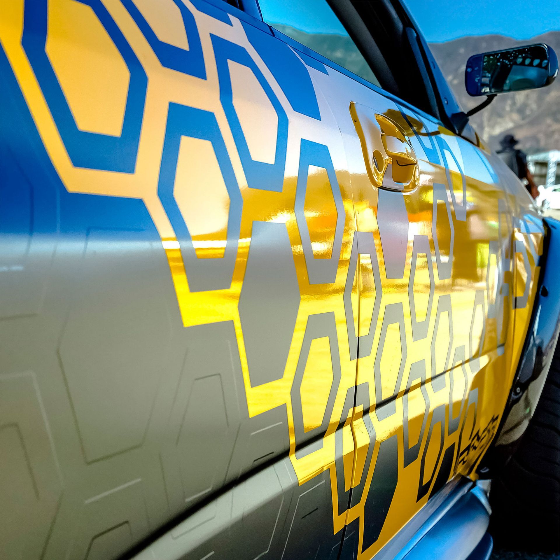 A blue and yellow car with a honeycomb design on it Custom Signs & Signage by Fulham Signs 