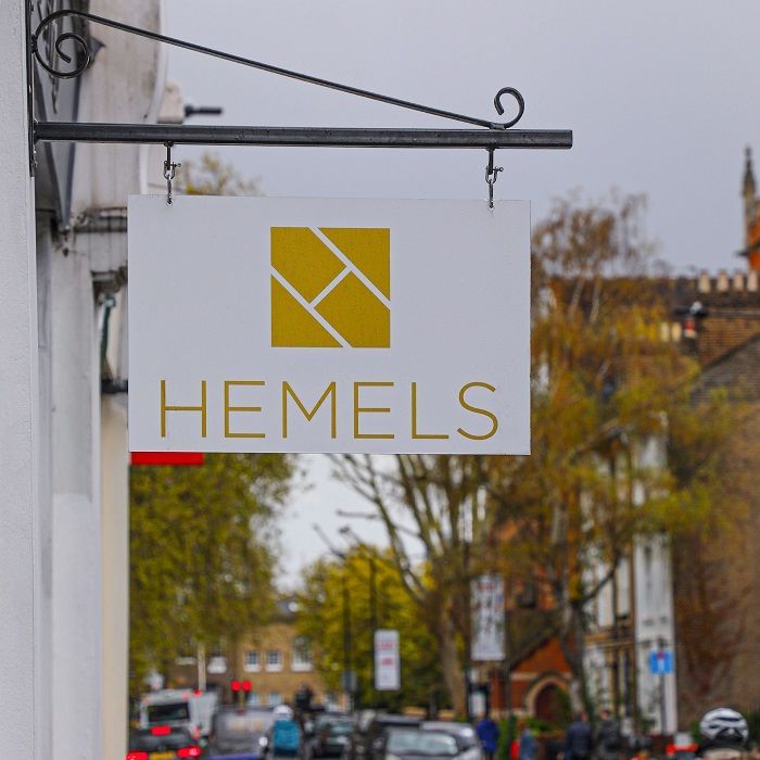 A projection double sided sign for hemels hangs from the side of a building
