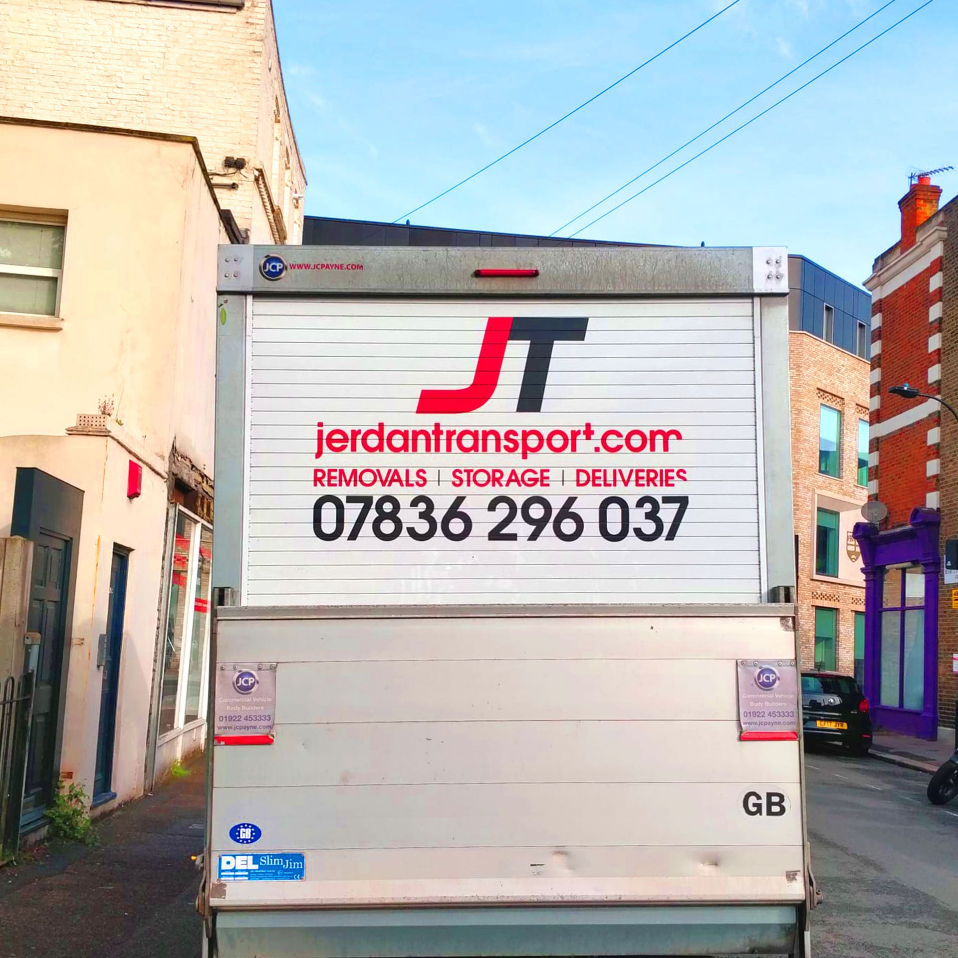 A white truck with a sign on the back that says jordantransport.com Custom Signs & Signage by Fulham Signs 