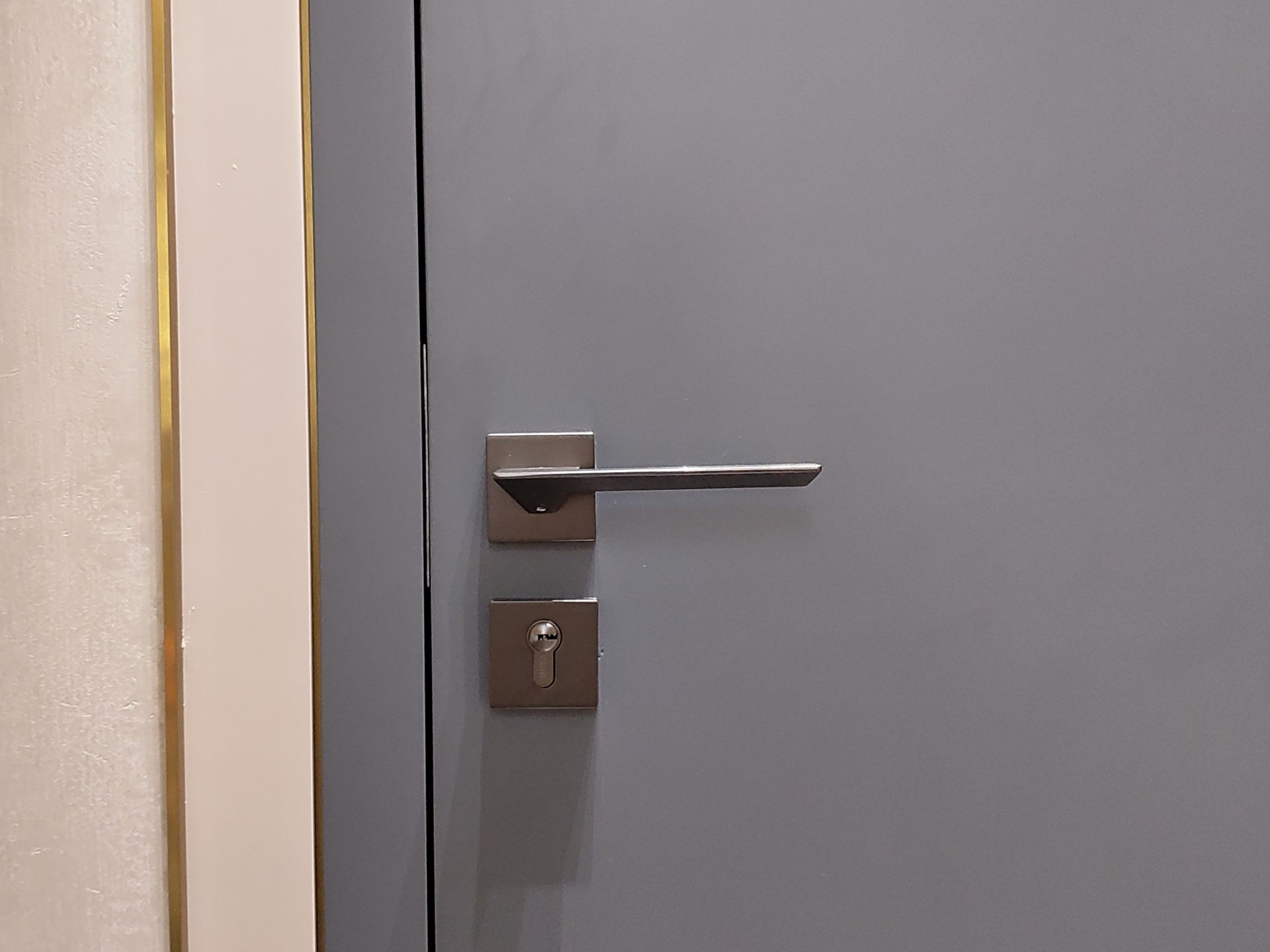 Gray door with silver handle and keyhole.