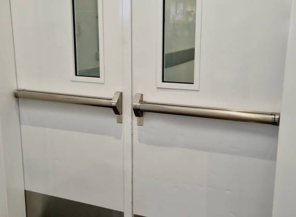 White double doors with metal push bars and small glass windows.