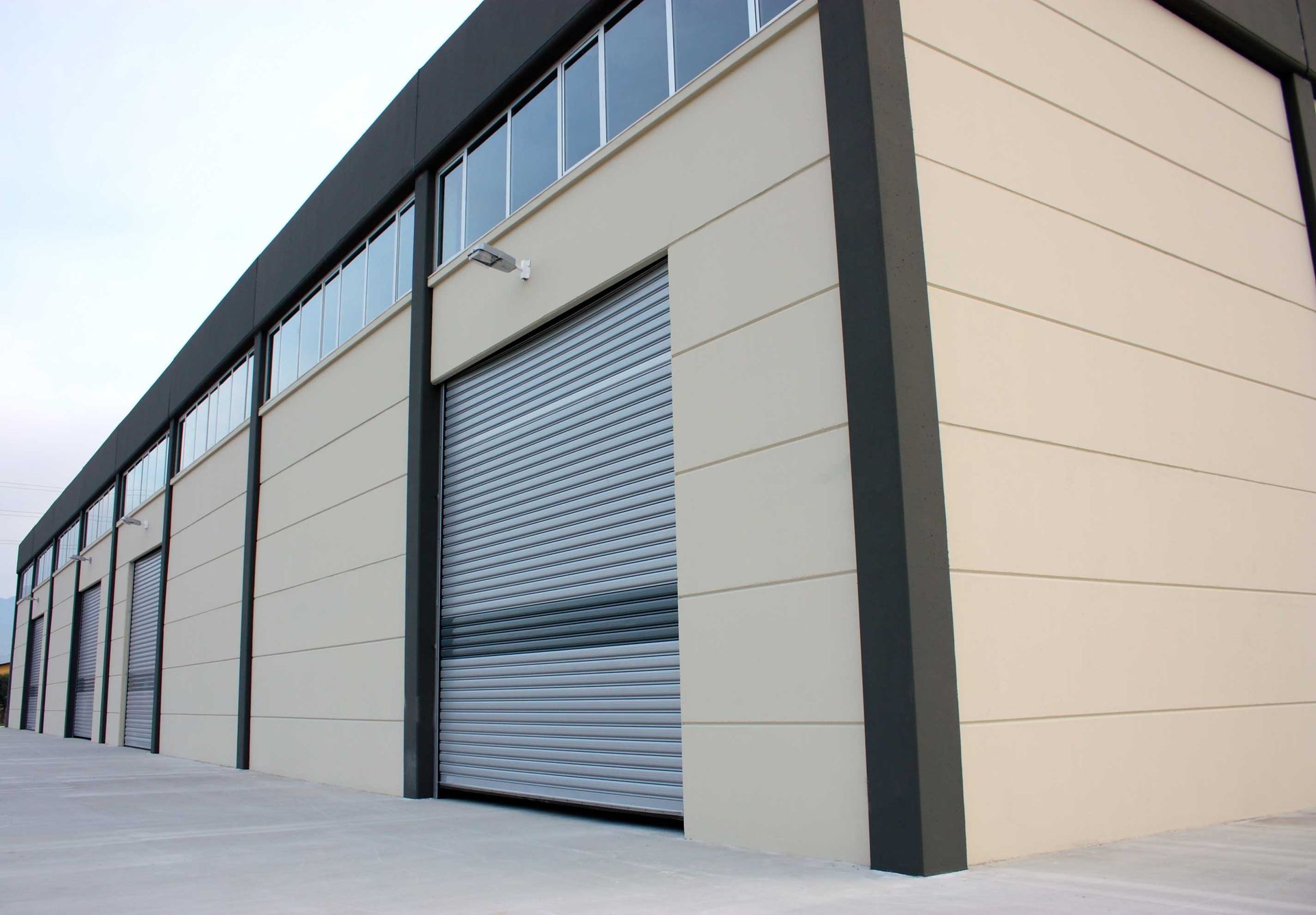Exterior of a commercial building with large gray roll-up door.
