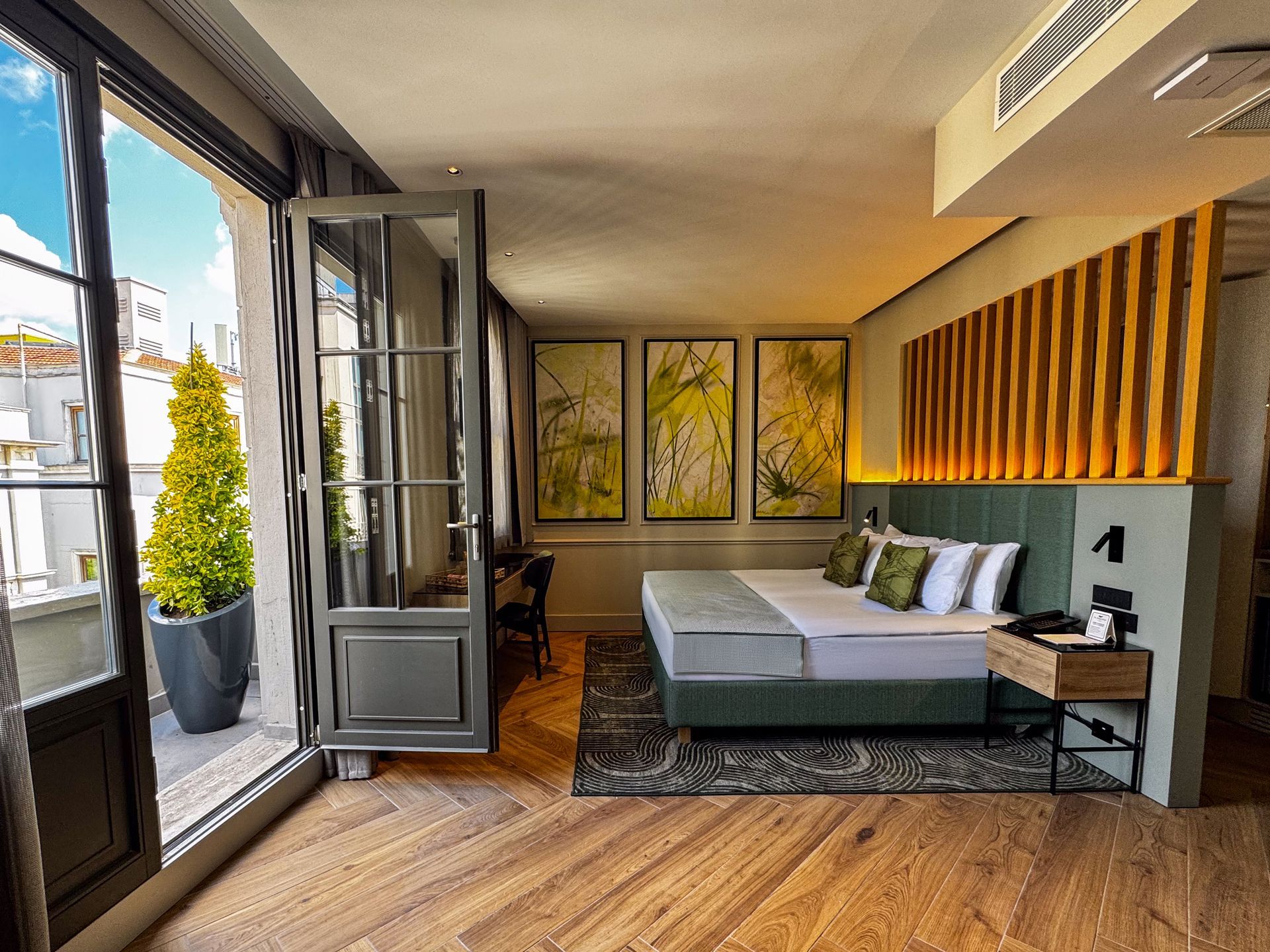 The Wings Hotels Pera | A hotel room with a large bed and a desk