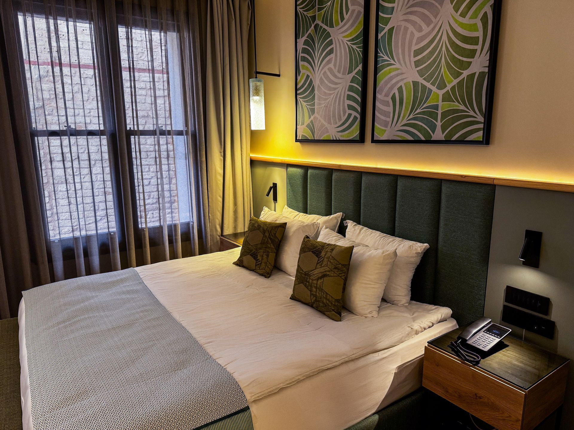 The Wings Hotels Pera | A bedroom with a green bed and white sheets
