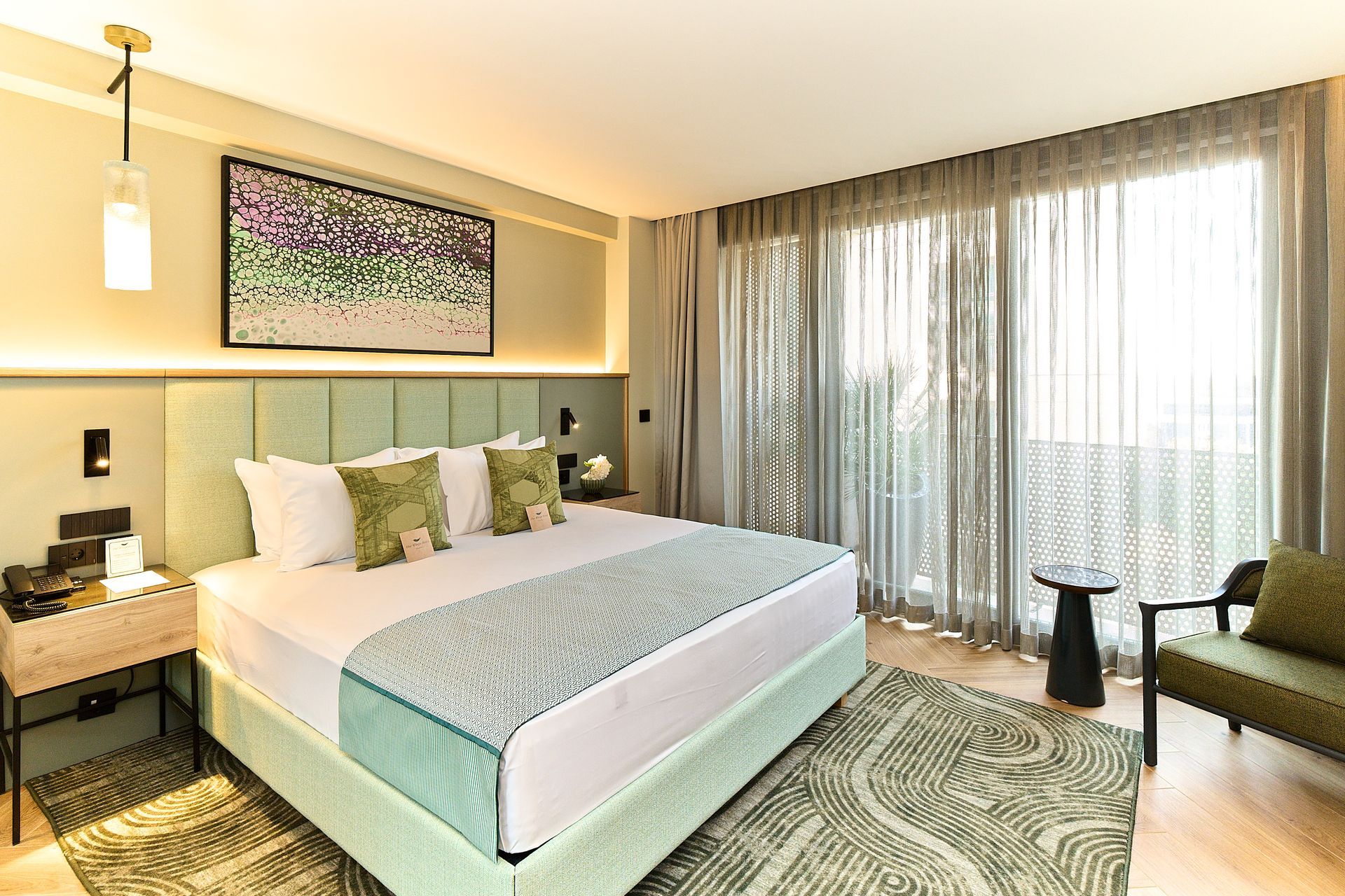 A hotel room with two beds , a chair , a desk and a mirror.