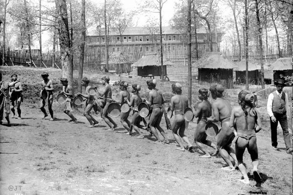 A black and white photo of a group of people running in a field.