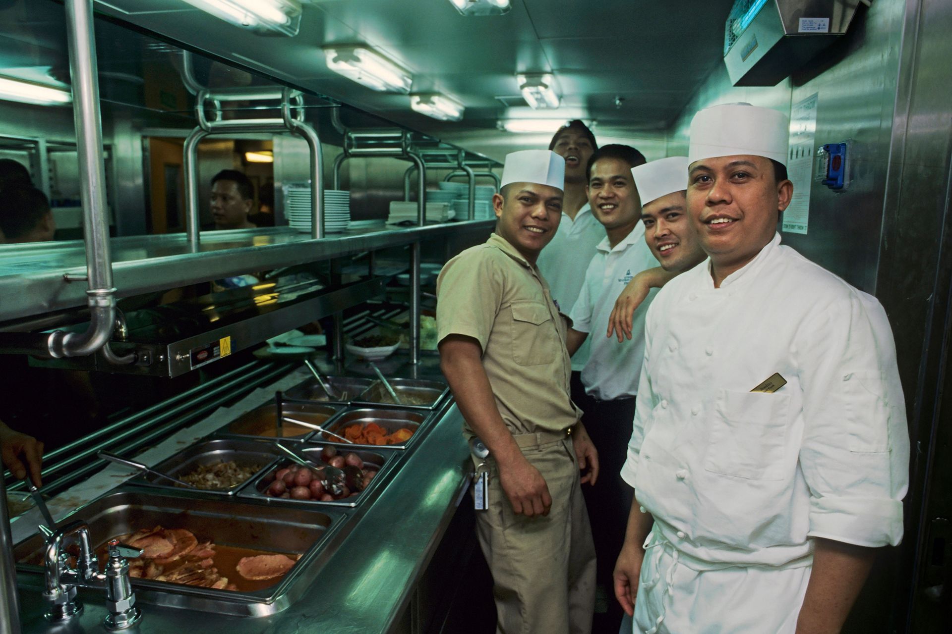 A group of chefs posing for a picture in a kitchen