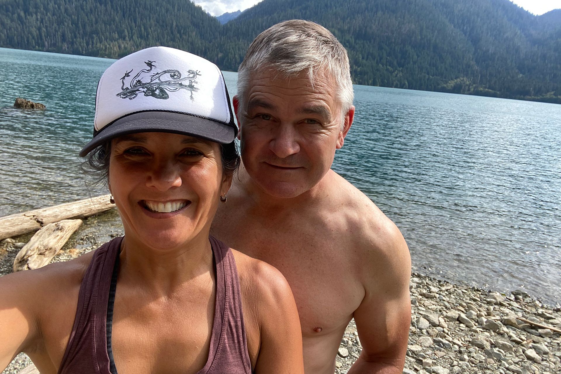 A man and a woman taking a selfie in front of the water