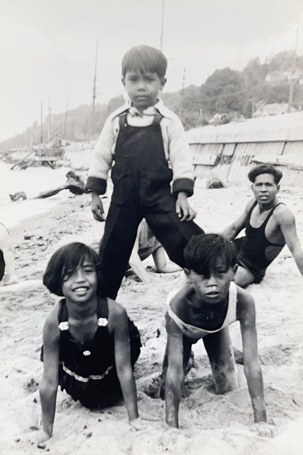 A black and white photo of children playing in the sand