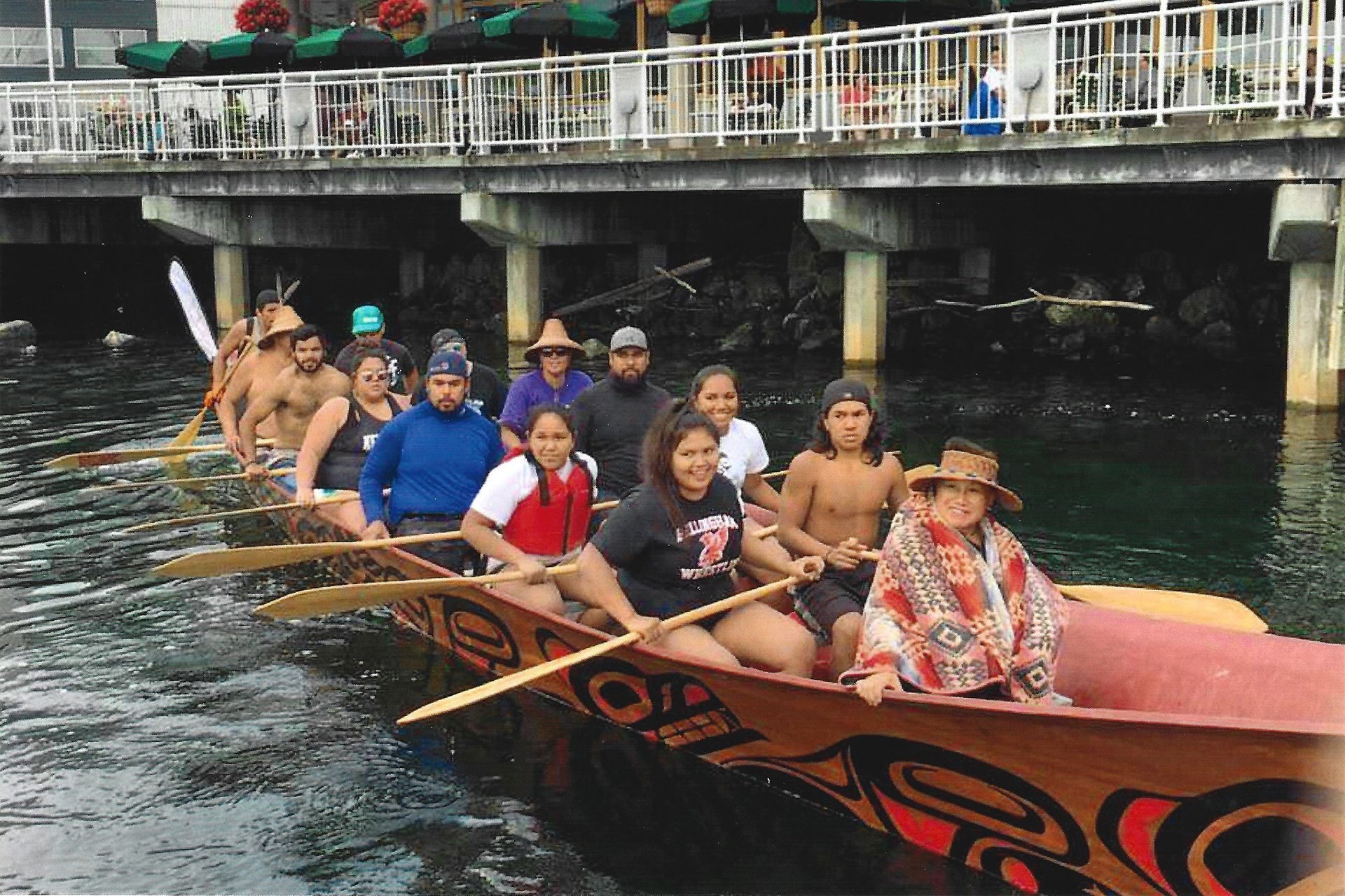 A group of modern-day Suquamish people row a canoe in the water