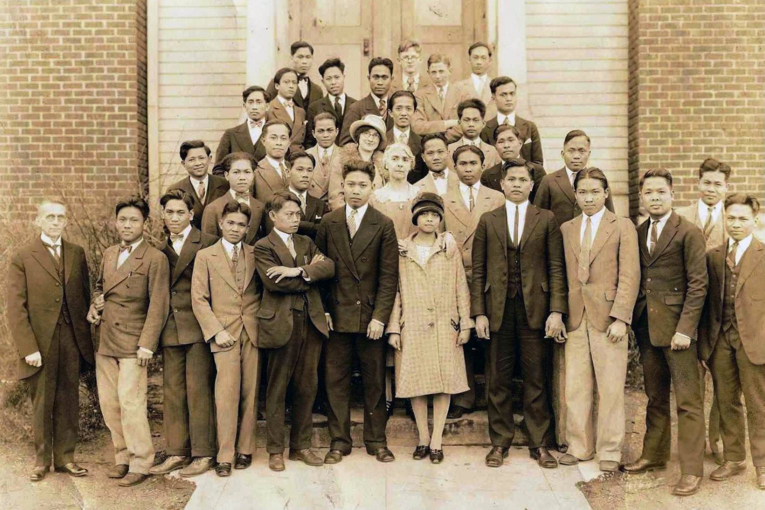 A group of people are posing for a picture in front of a building