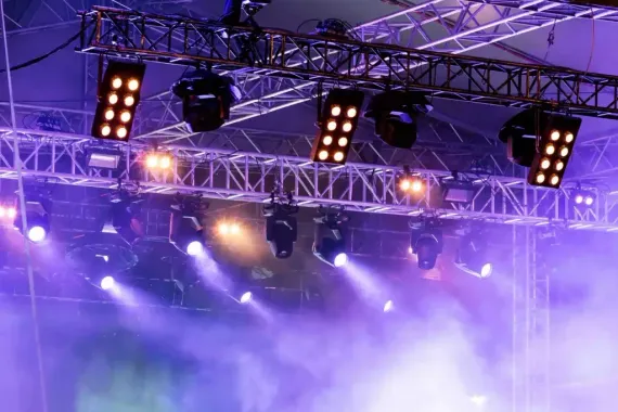 A stage with purple lights and smoke coming out of it.