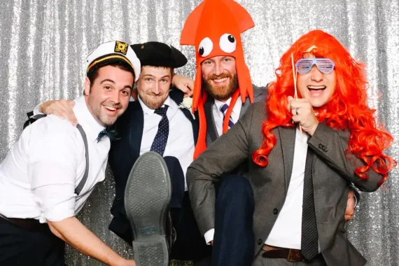 A group of men are posing for a picture in a photo booth.