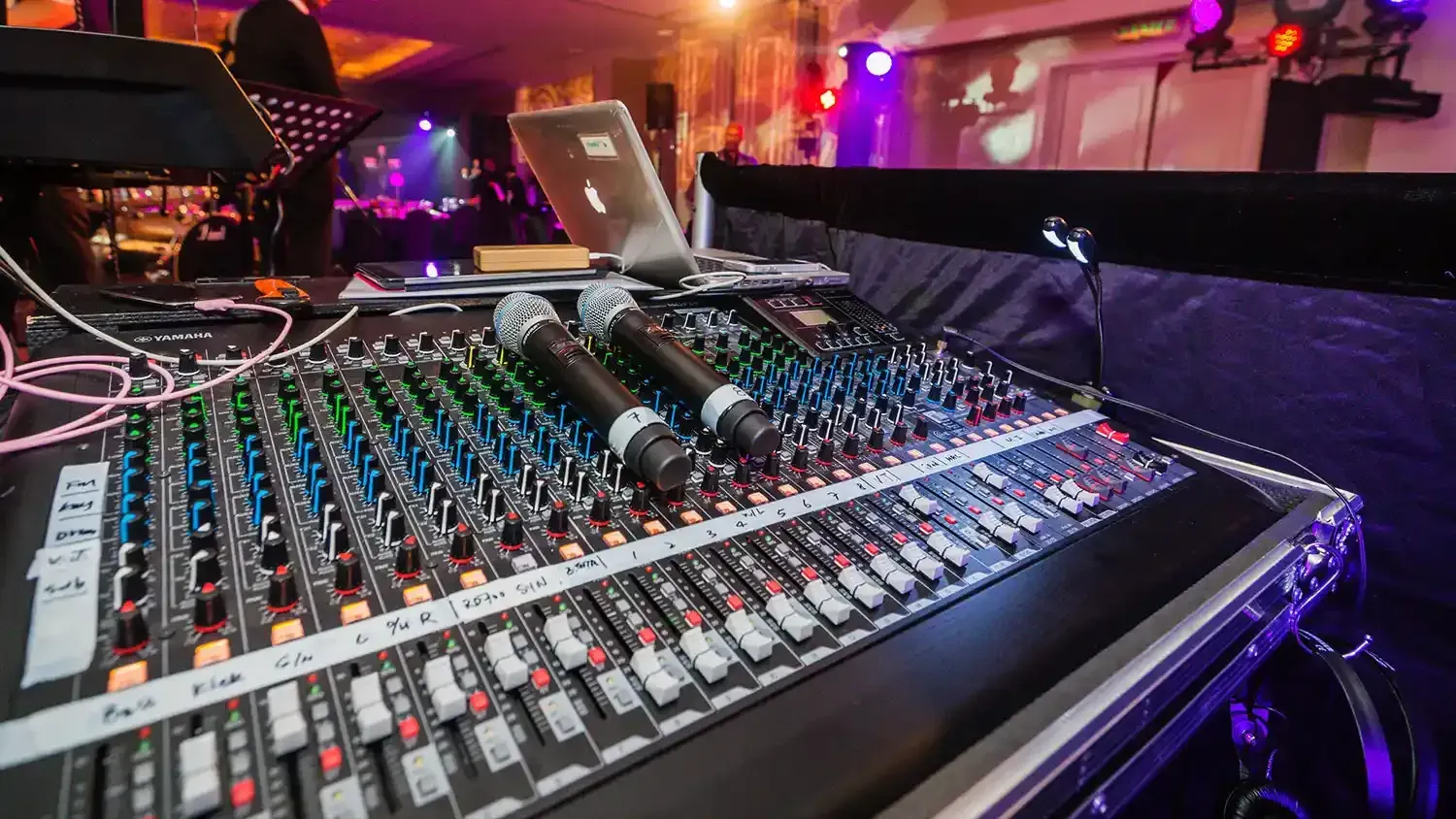 A mixer with two microphones and a laptop on it.