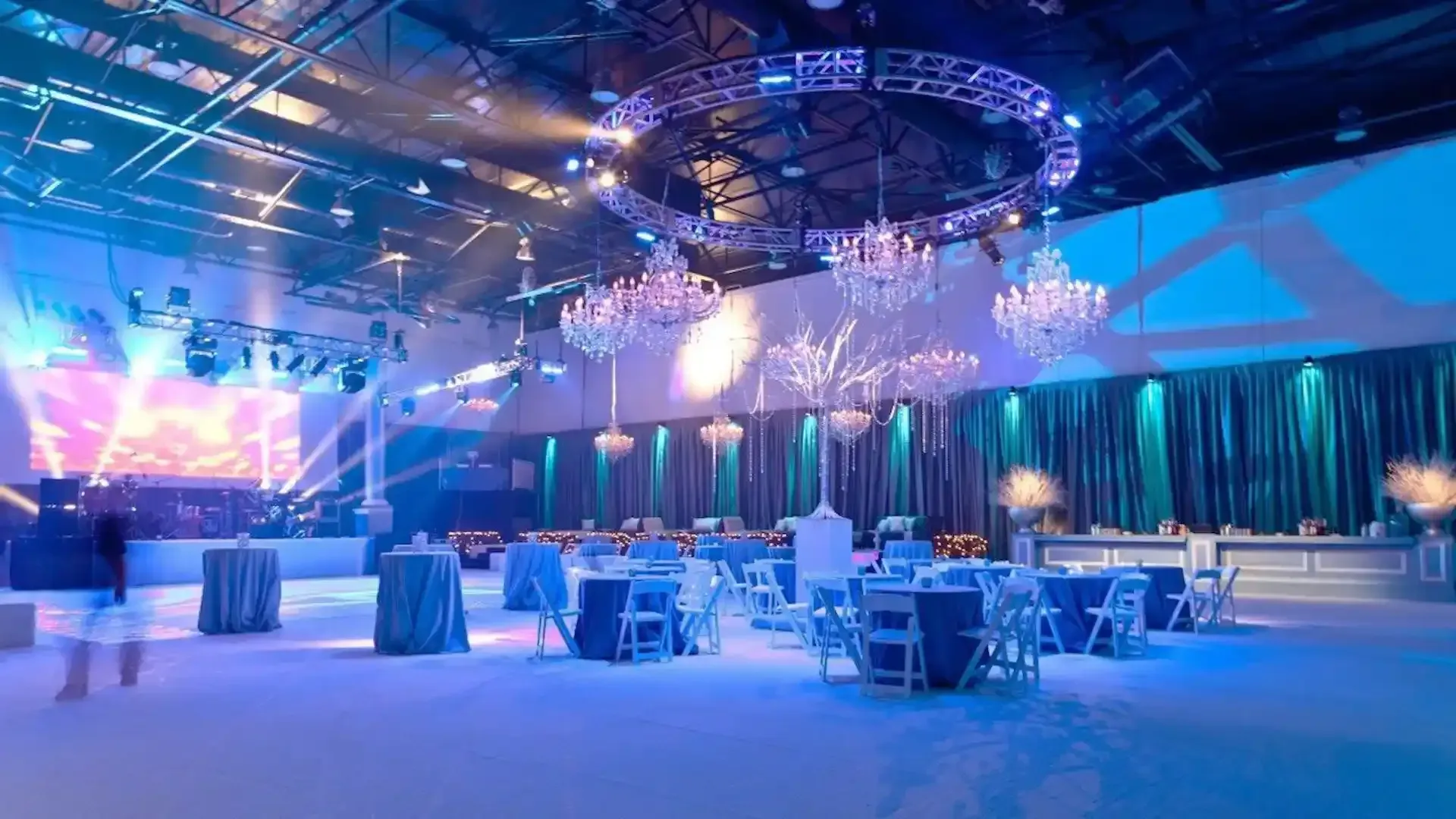A large room with tables and chairs set up for a party.
