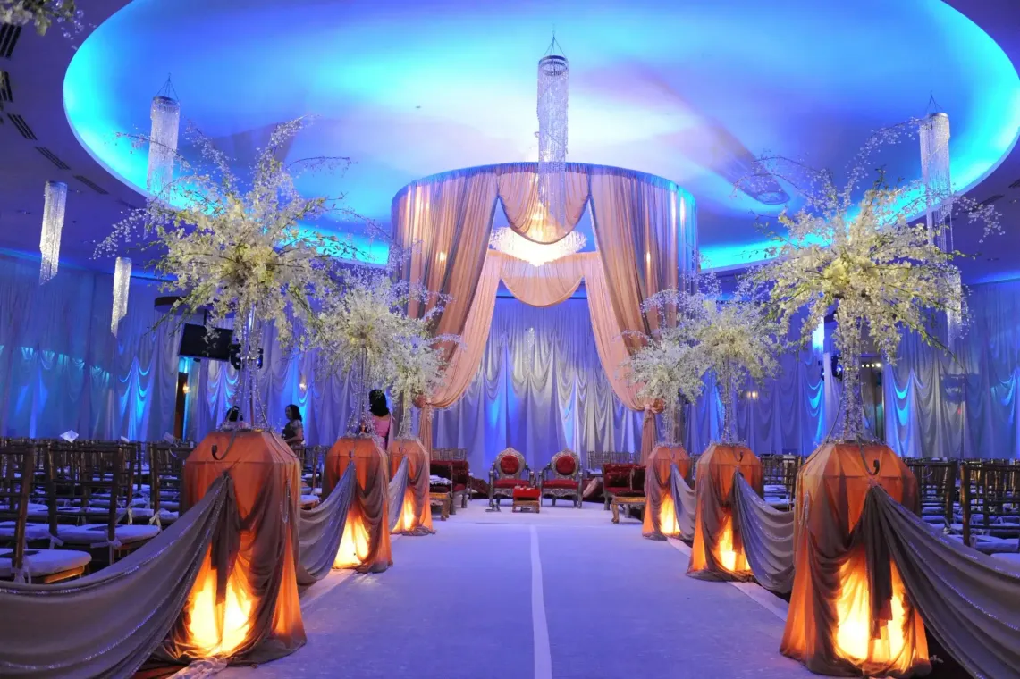 A large room decorated for a wedding with blue lights and flowers.