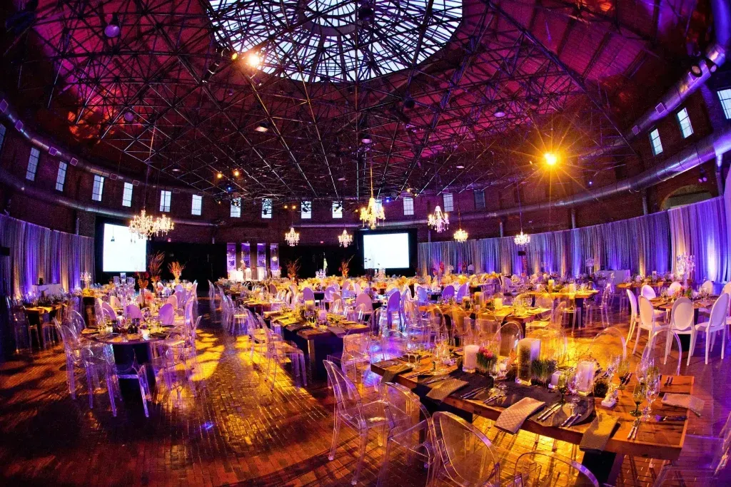 A large room with tables and chairs set up for a party.