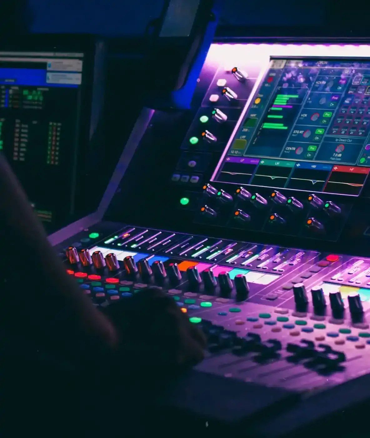 A person is using a mixer in a dark room