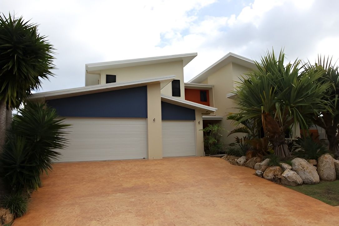 Modern House With White Garage Doors — Peterson Property Valuations Brisbane in Caloundra West, QLD