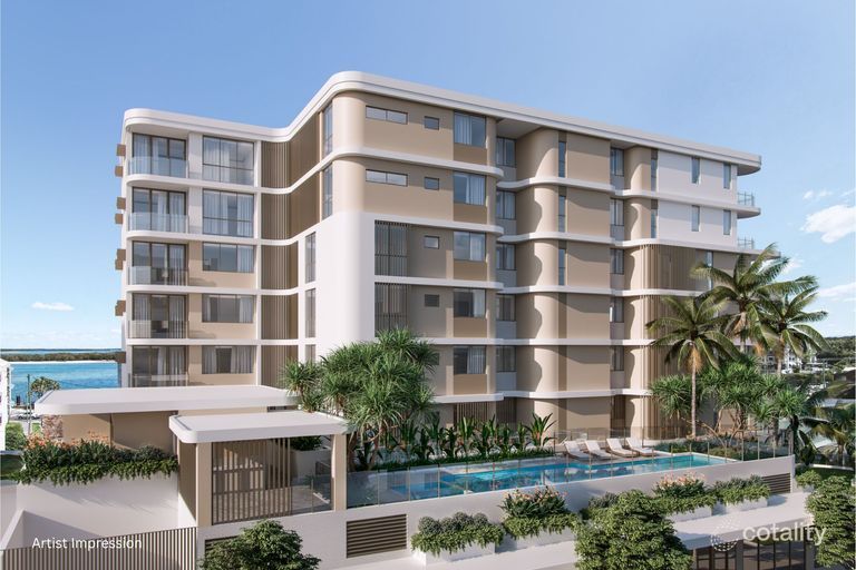 Multi-story modern building with pool, trees, and blue sky.