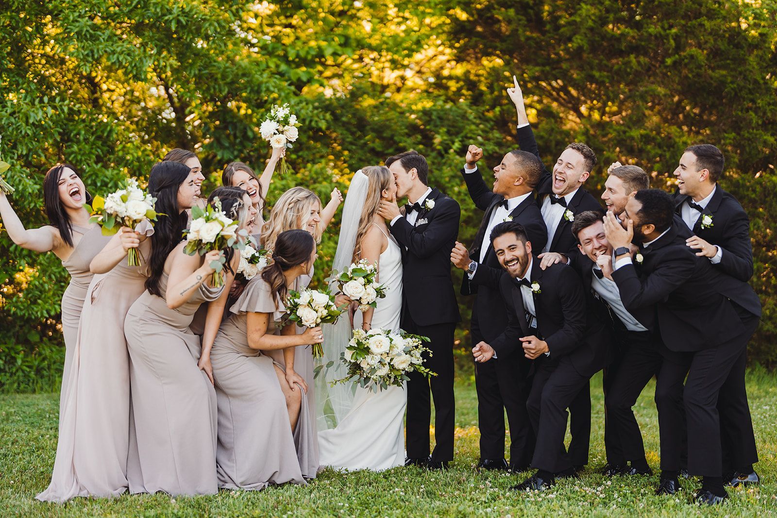 A bride and groom are posing for a picture with their wedding party.