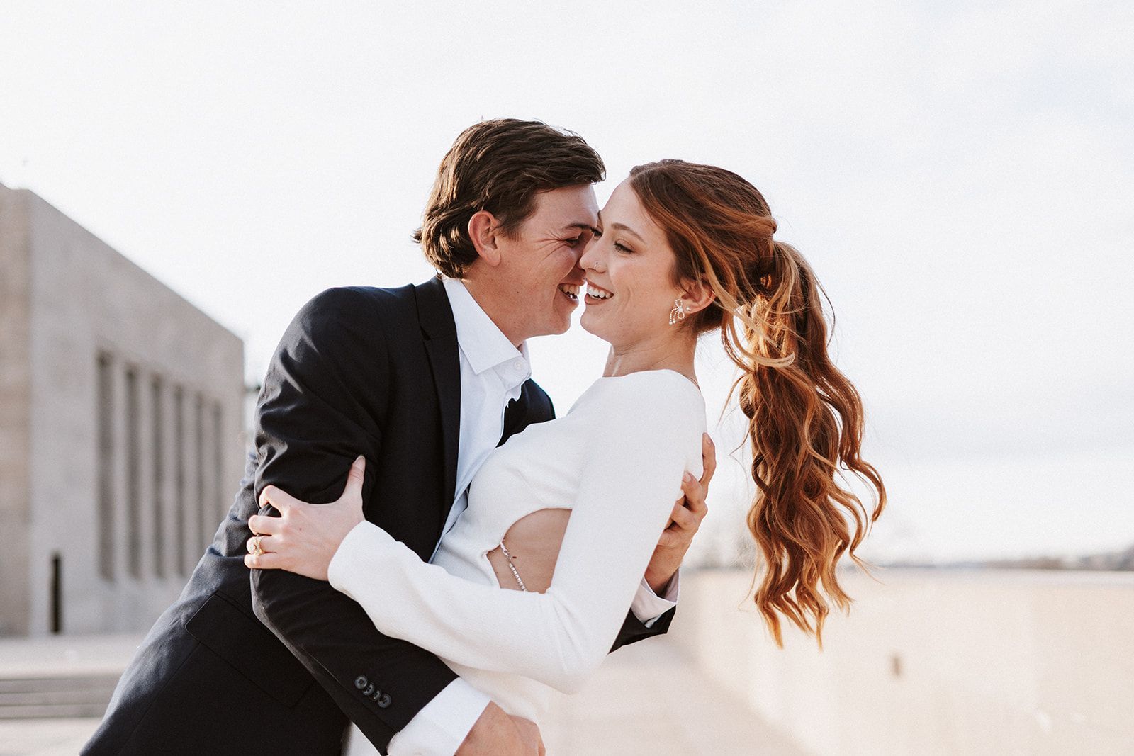 A man is holding a woman in his arms and they are kissing.