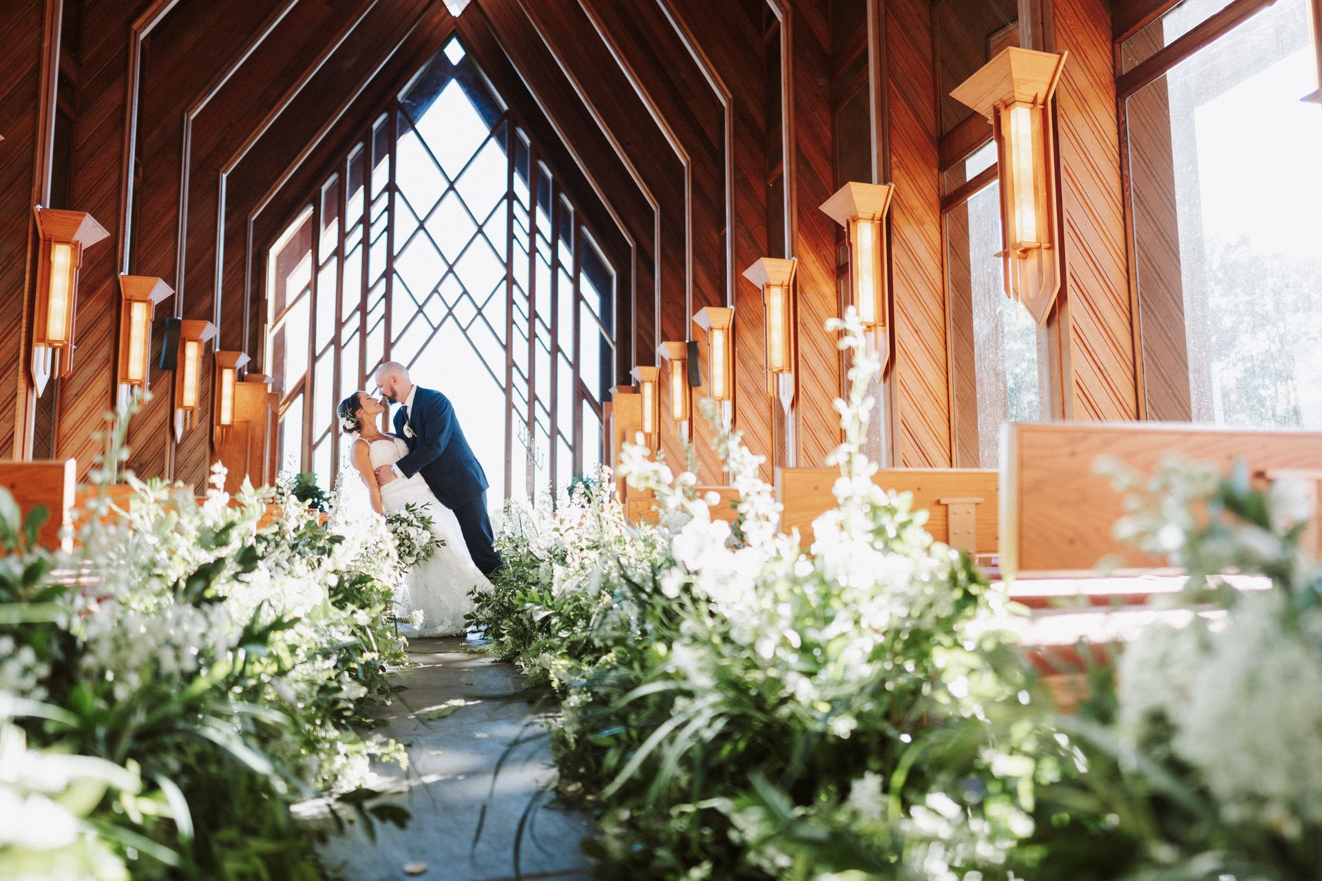 A bride and groom are kissing in a church.