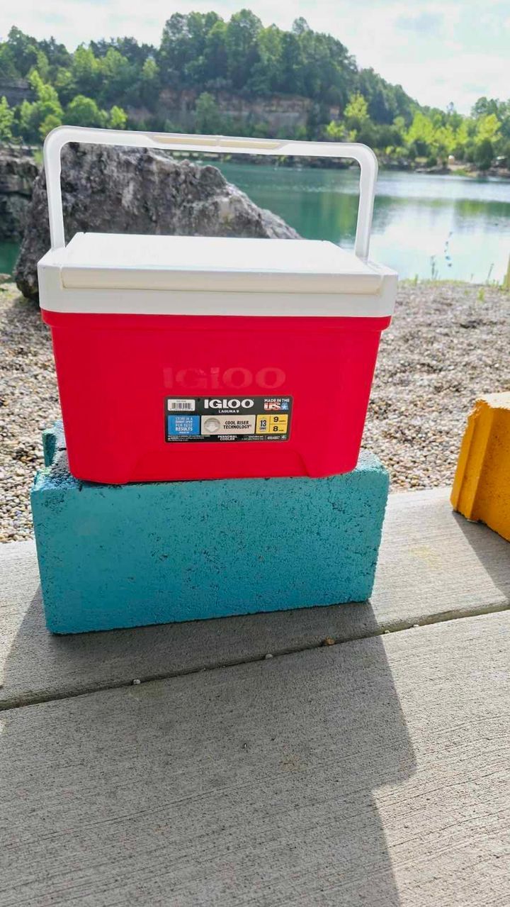 A red igloo cooler is sitting on top of a blue cooler.