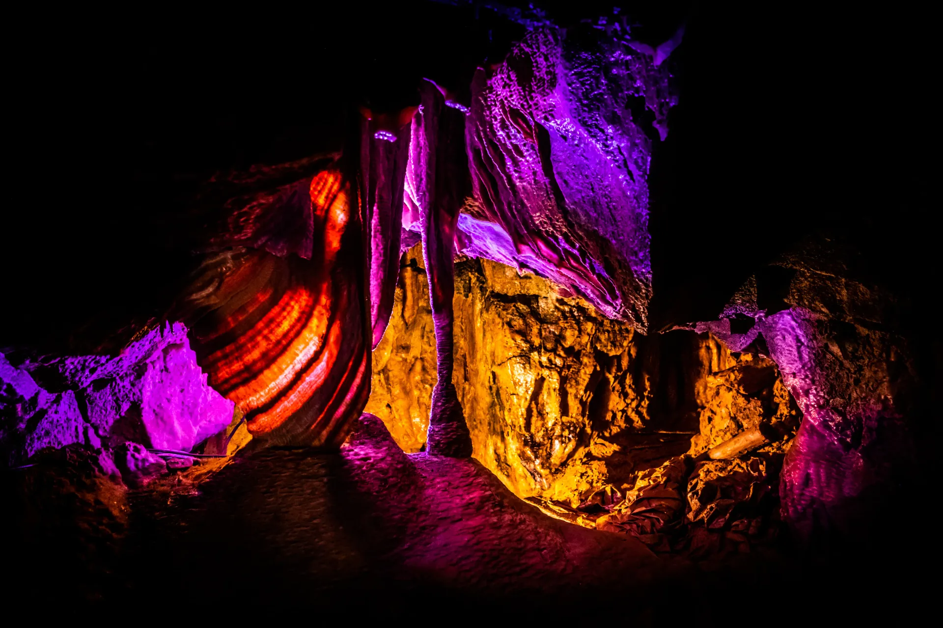 A cave filled with purple and orange lights at night.