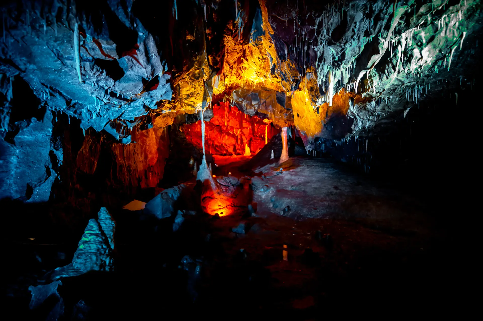 A cave with a lot of ice and a lot of lights coming out of it.