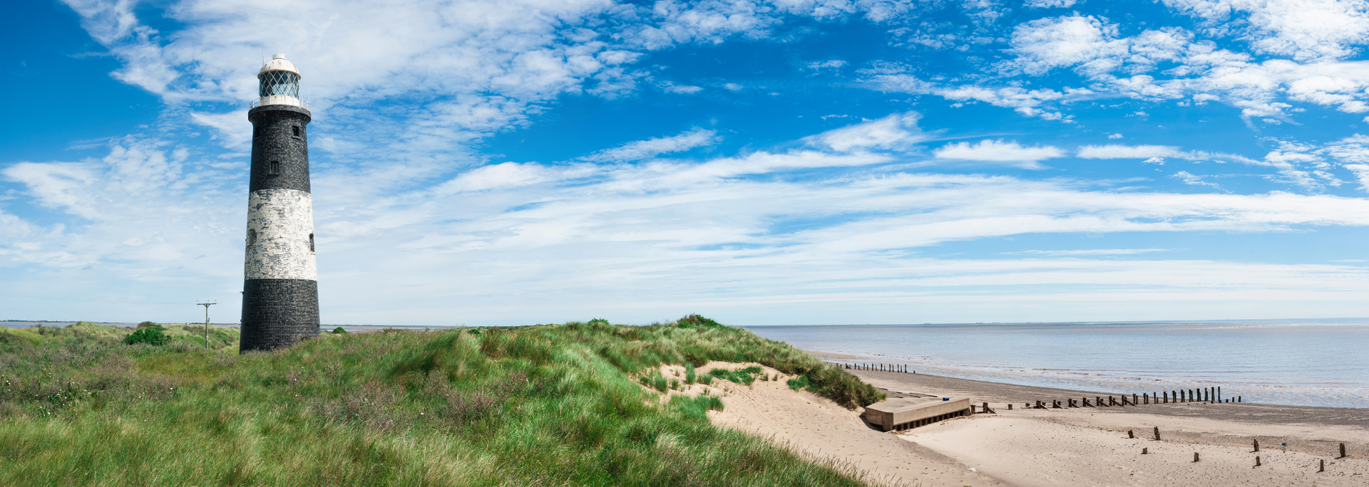 Picture of a Lighthouse on the sea front overlooking a sandy beach