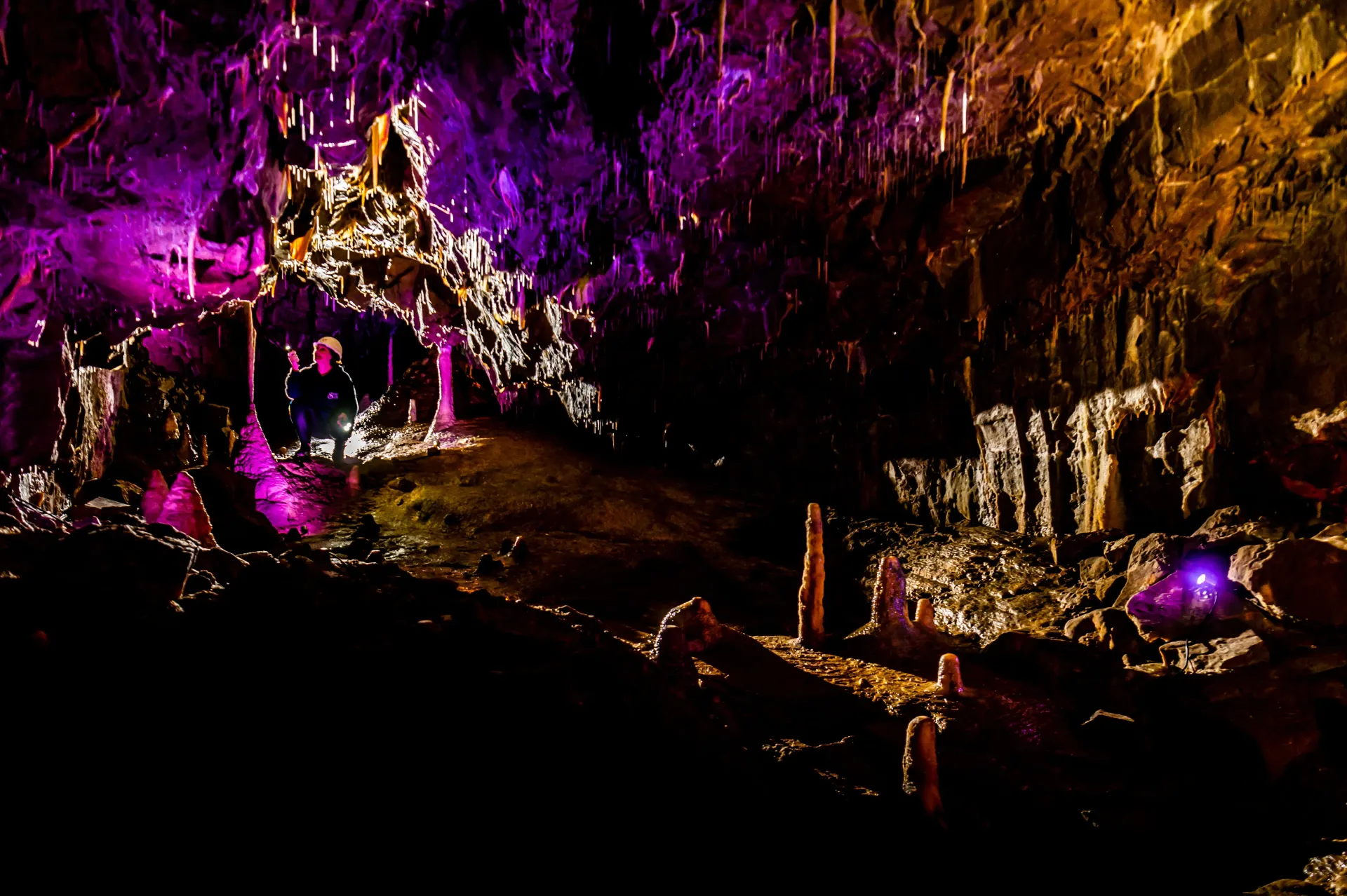 A cave filled with purple and orange lights at night.
