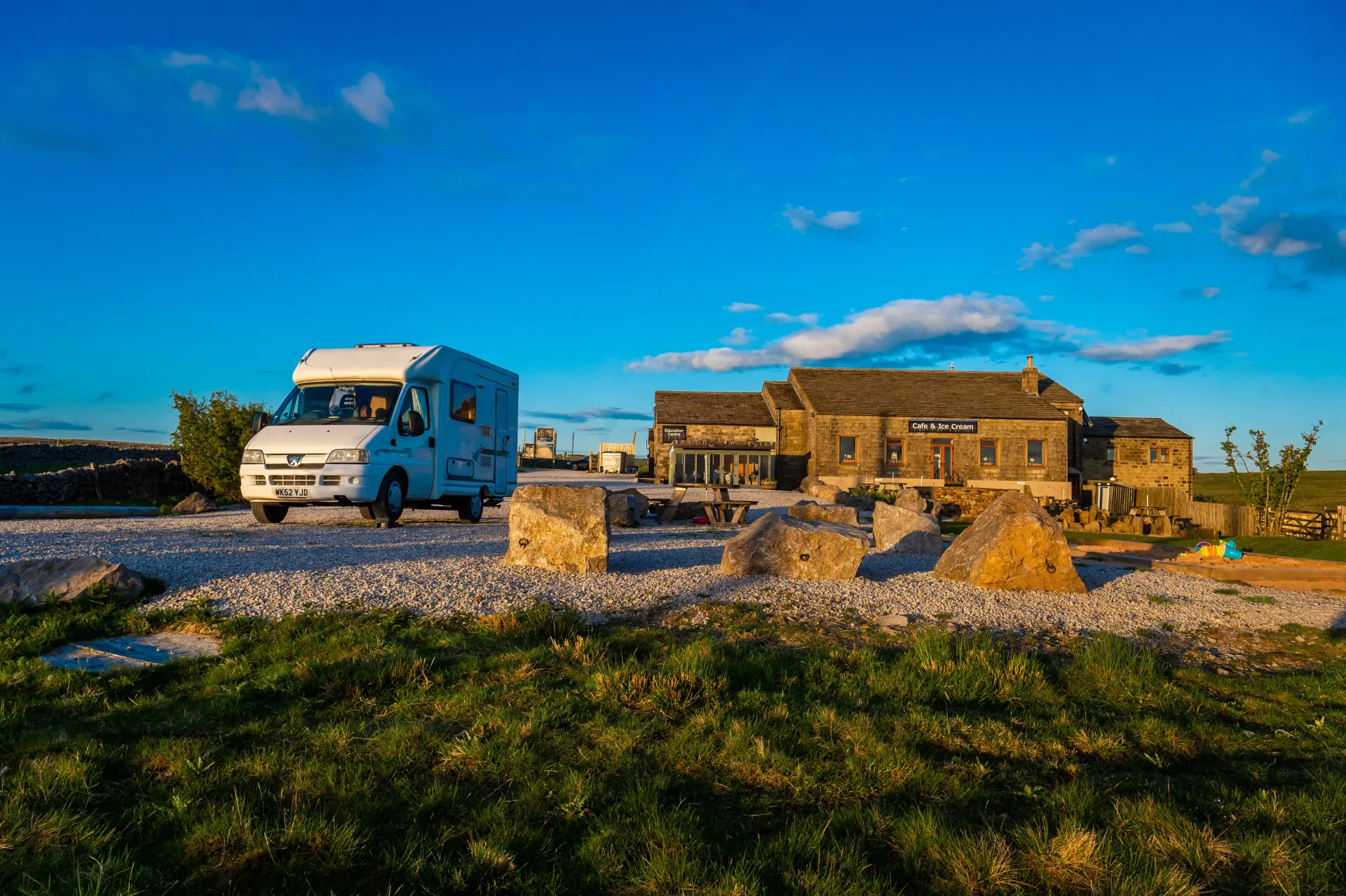 A rv is parked in front of a stone building.