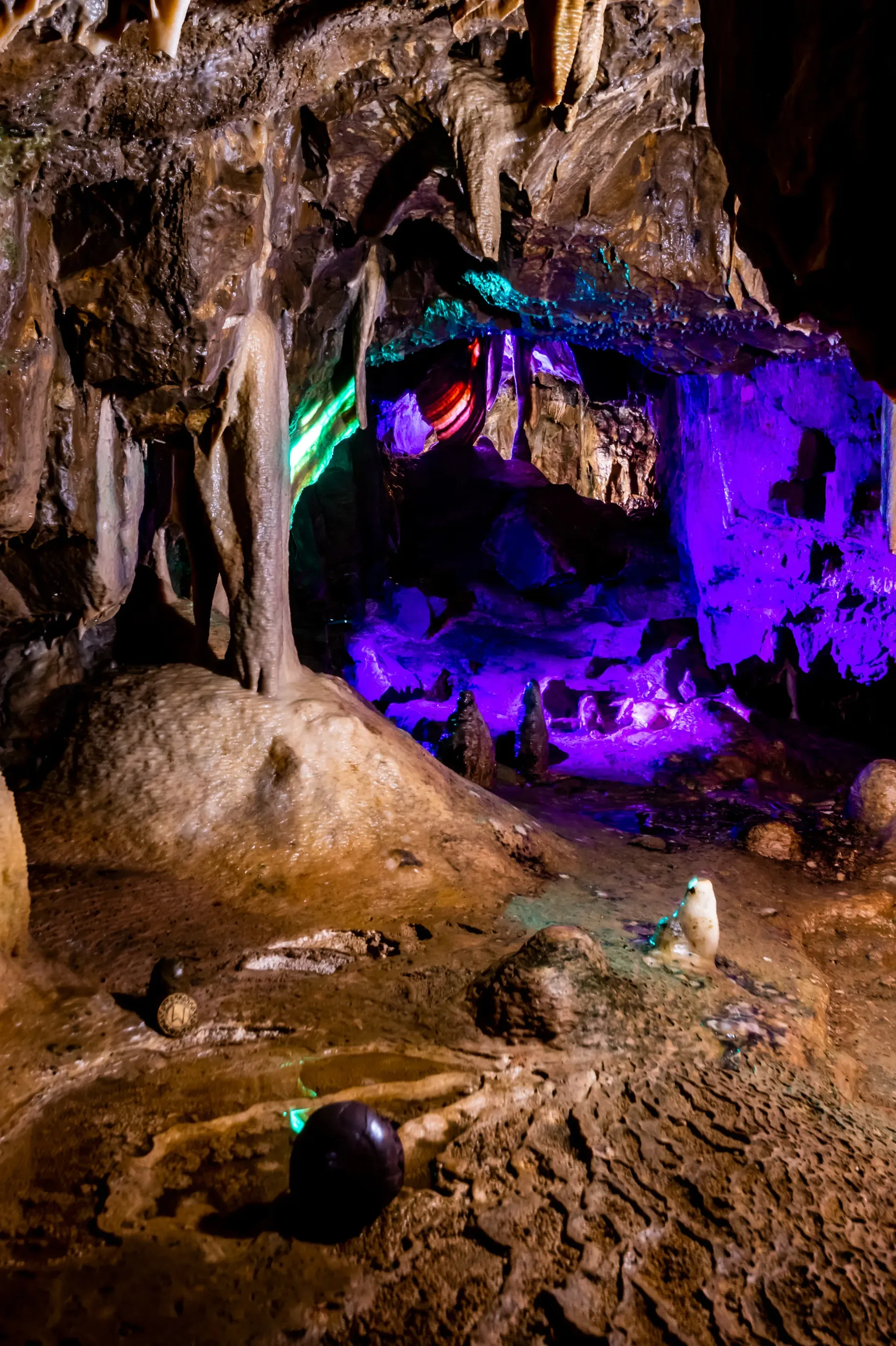 A cave with purple and green lights on the walls and ceiling.