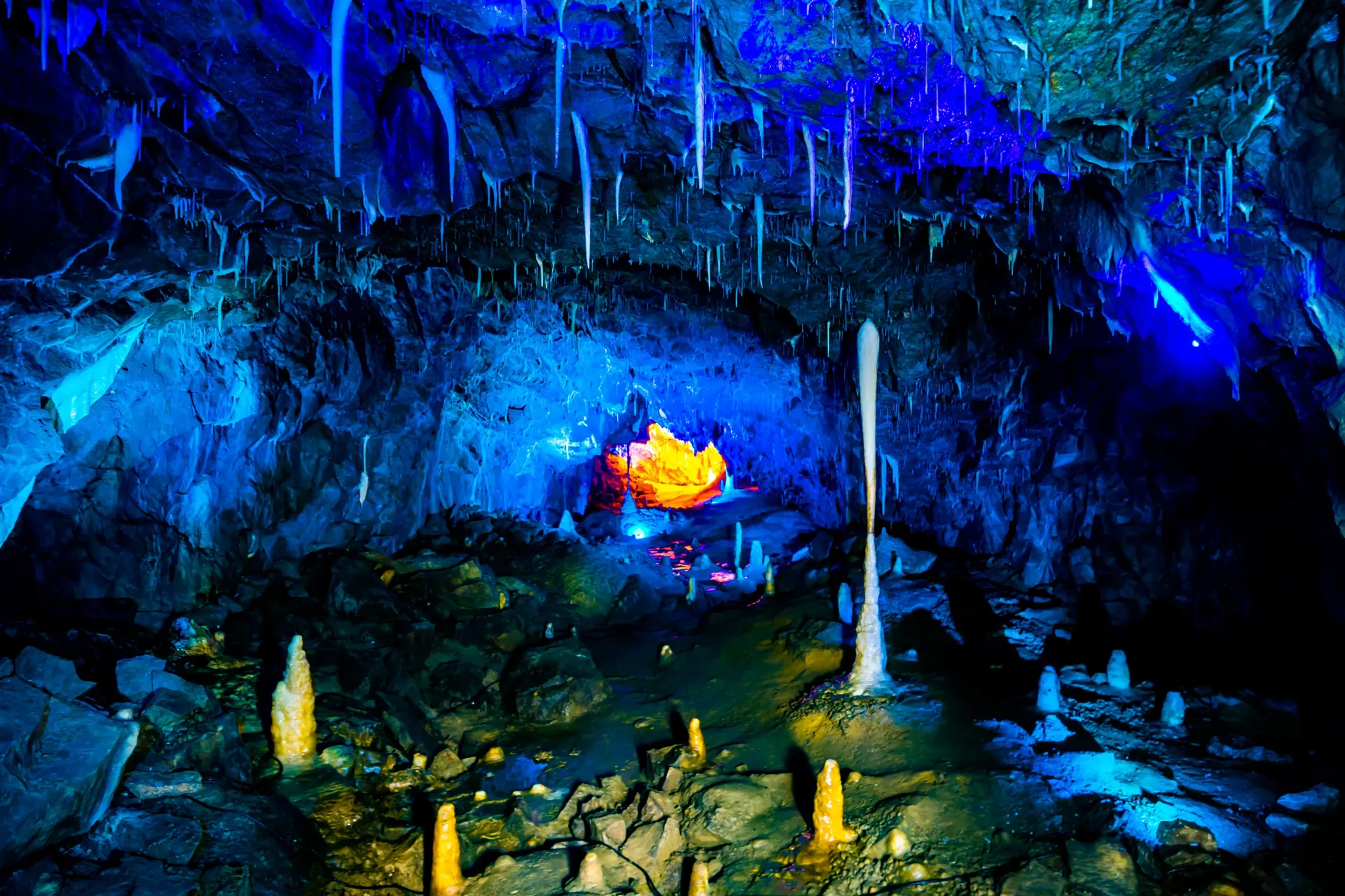A person is sitting in a cave with blue lights.