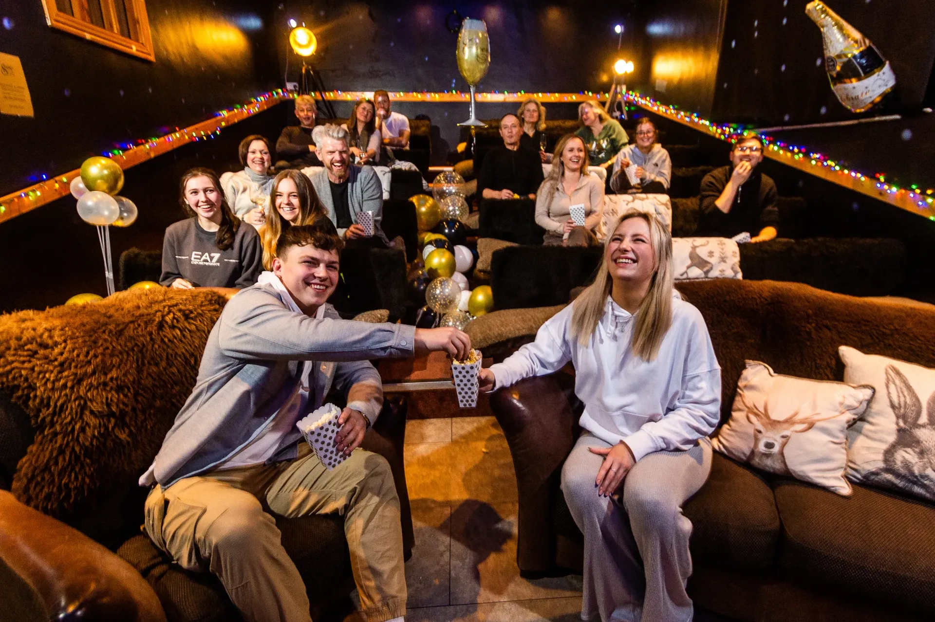 A man and a woman are sitting on a couch in front of a group of people.