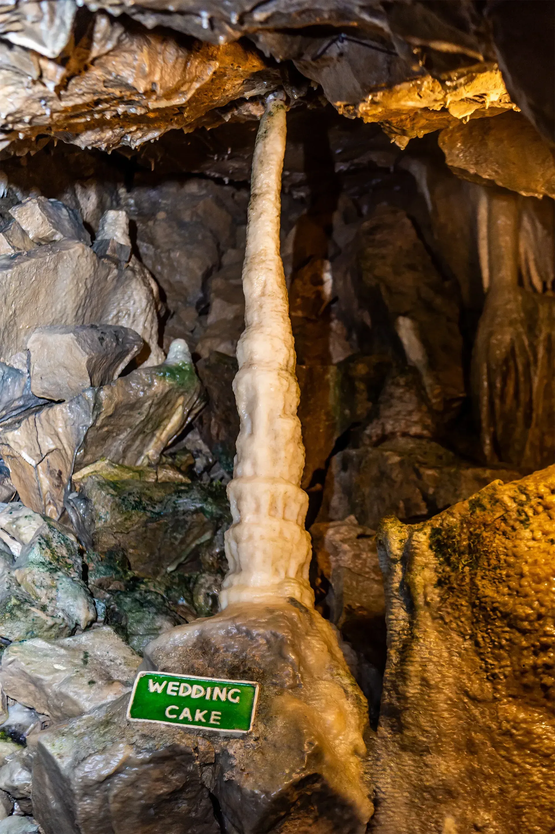 A waterfall in a cave with a sign that says wedding cake.