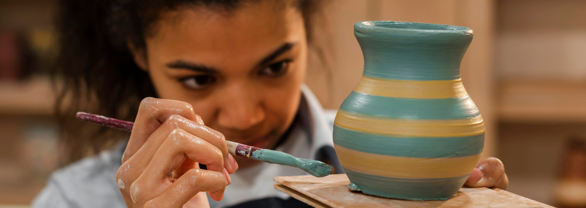 Picture of someone painting pottery. 