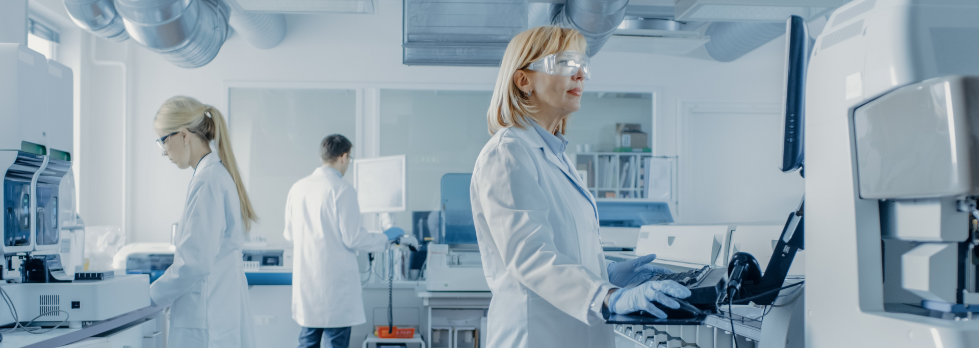 Picture of scientists working on technical equipment in a lab. Picture of scientists working on technical equipment in a lab.