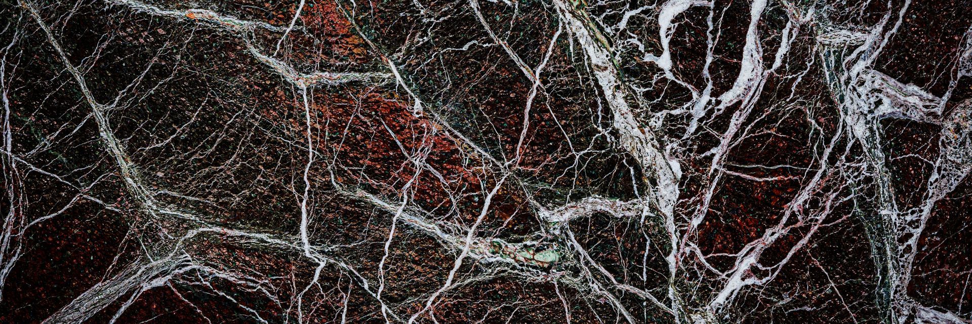 A close up of a spider web on a black surface.