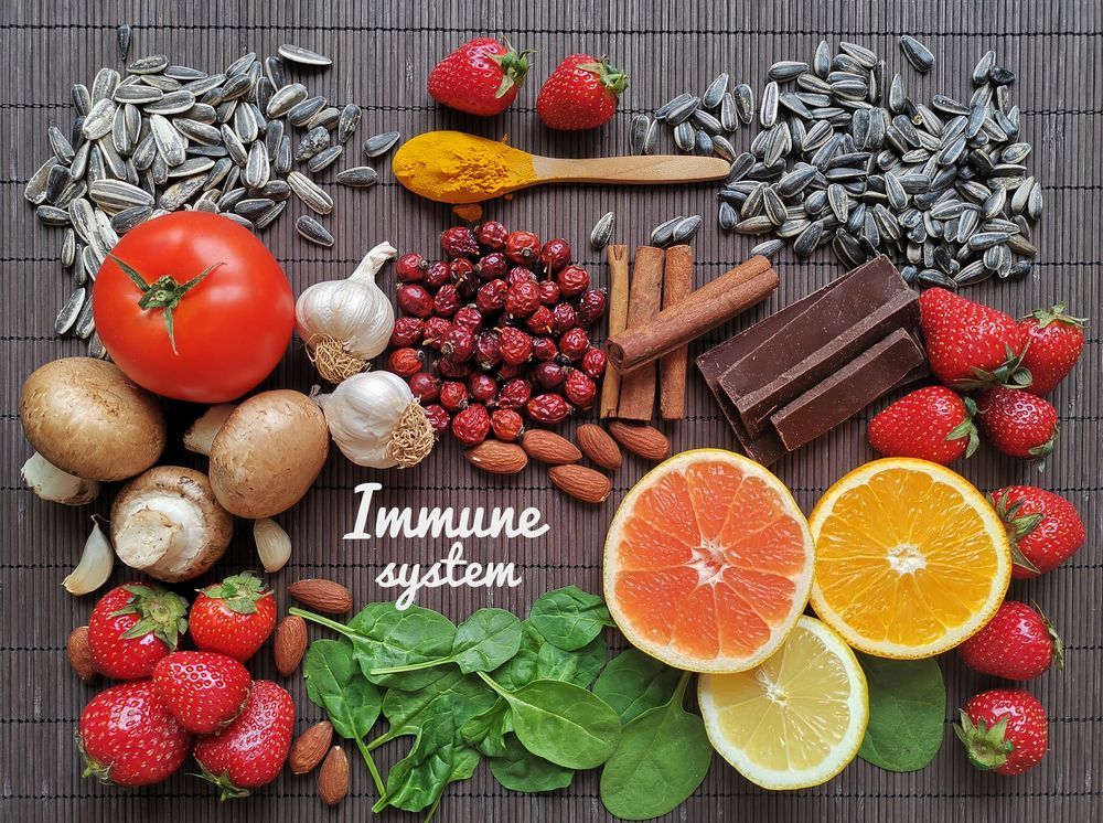 A variety of fruits , vegetables , nuts and spices are sitting on a bamboo mat.