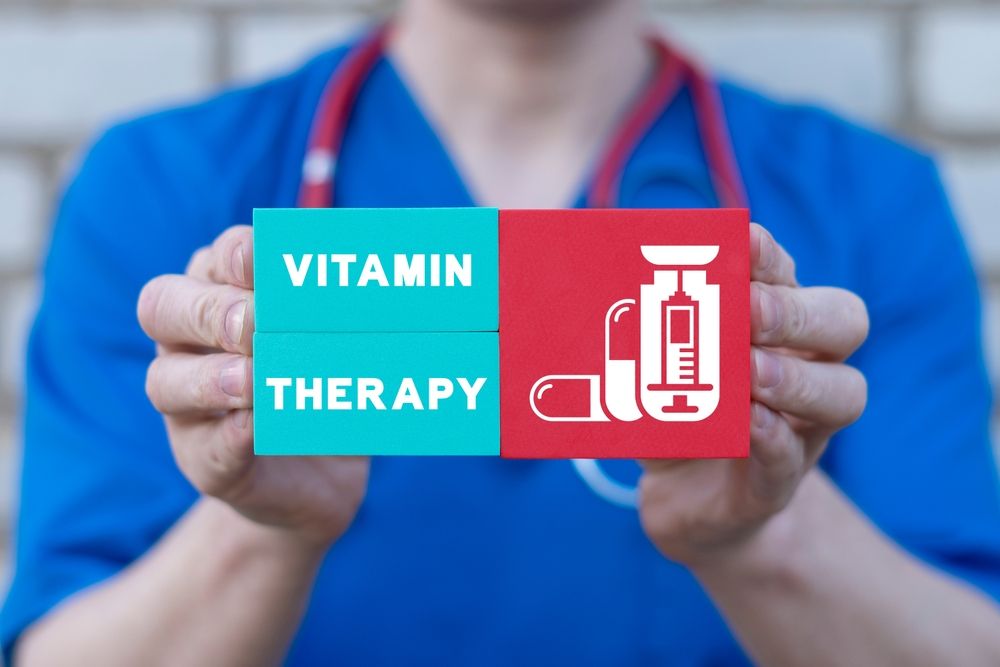 A doctor is holding a card that says vitamin therapy.