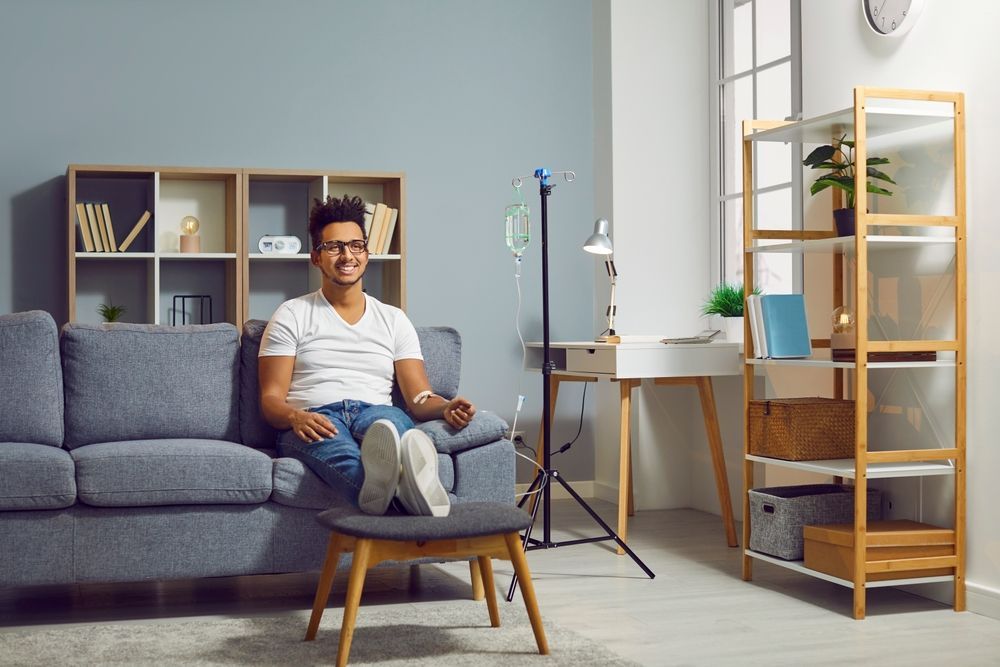 A man is sitting on a couch in a living room.